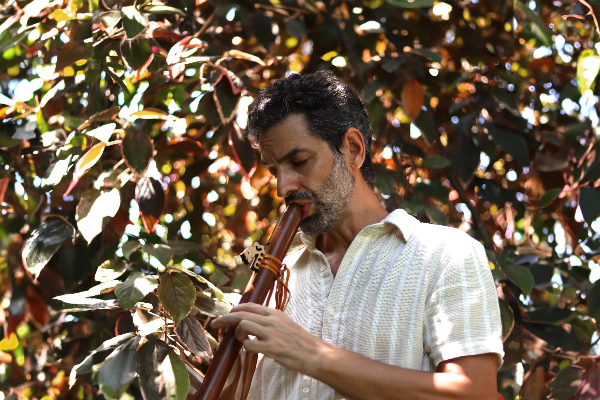 Ayres Soul tocando flauta no jardim do AMARA