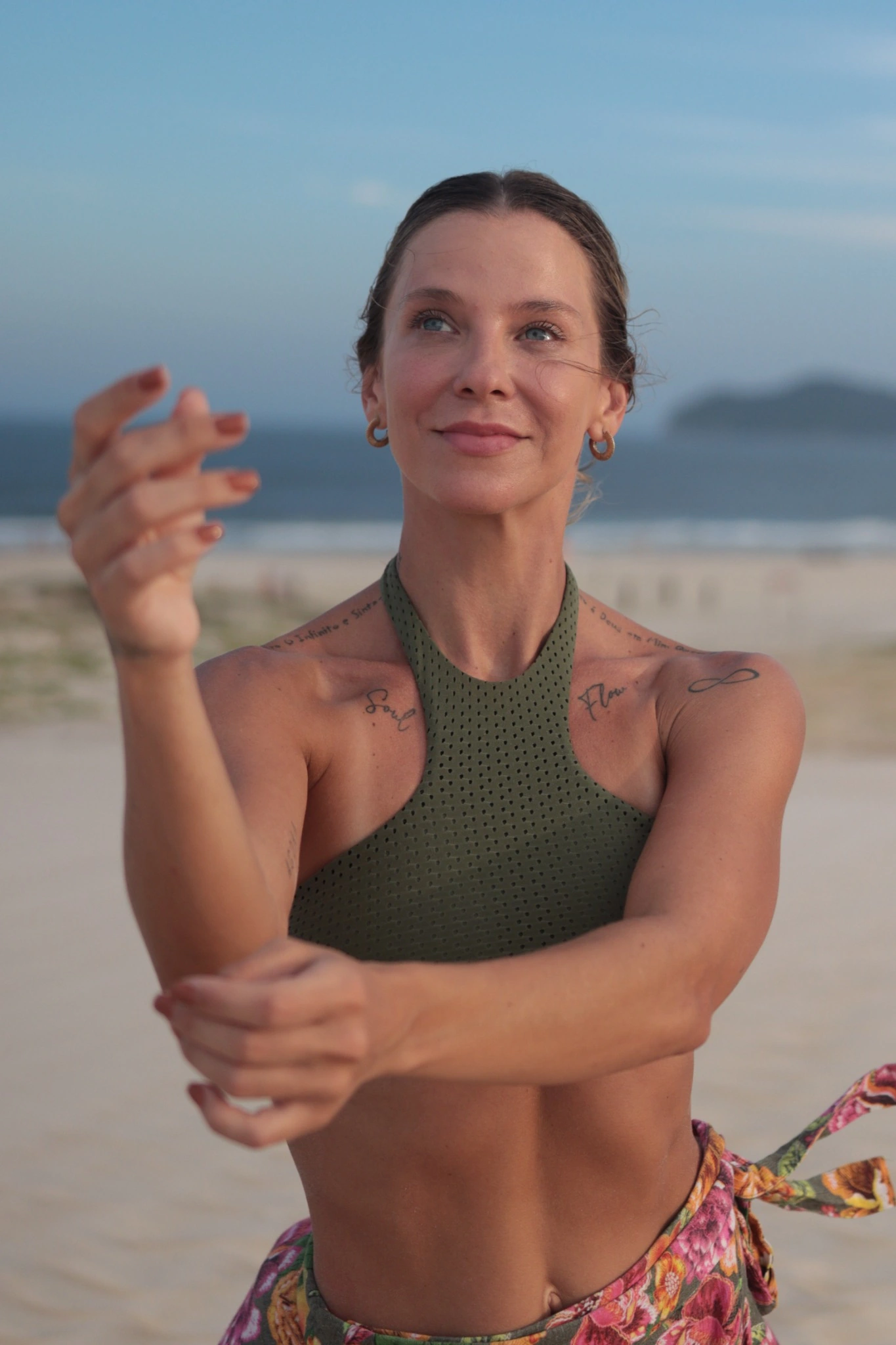 Brunna Schamann nas dunas, com uma das mãos elevada